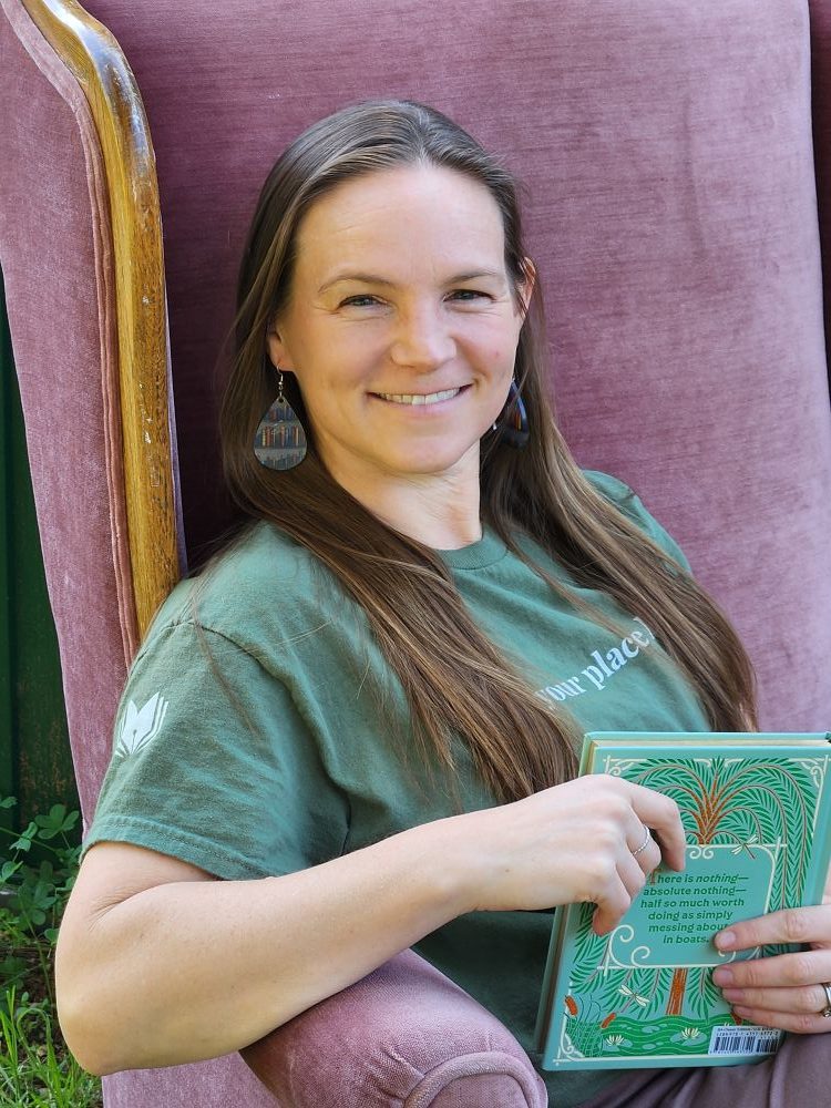 Woman in green top with green necklace smiles into the camera